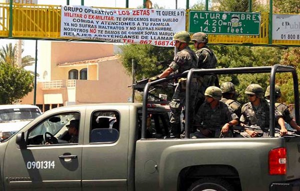 파일:지나가는 멕시코 군인 위 마약카르텔 광고.jpg